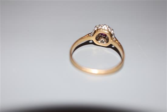 A mid 20th century yellow metal (stamped 18ct and Plat), ruby and diamond cluster ring, size L/M, gross 2.4 grams.